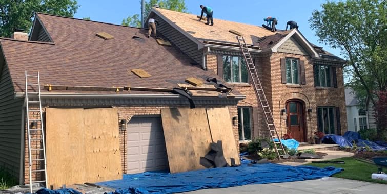 Roofing contractor inspecting roof after hail damage